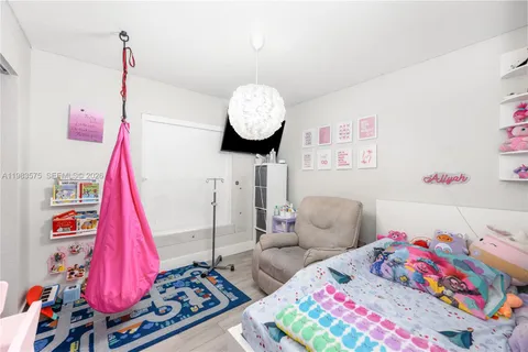 a living room with baby bed furniture and a wooden floor