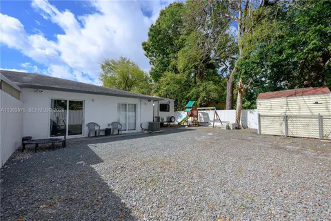 a view of a house with backyard and a tree