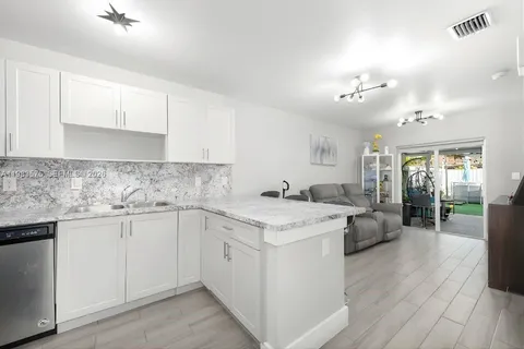a kitchen with granite countertop a sink stove and cabinets