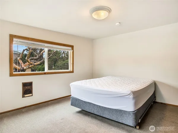 a bed sitting in a bedroom next to a window