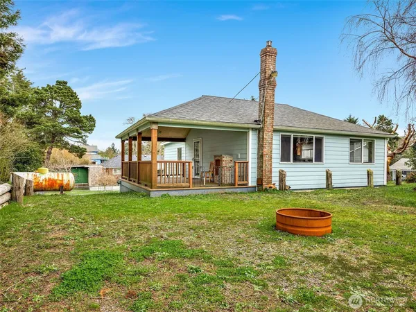 a view of a patio with table and chairs and a large tree