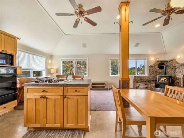 a dining table with chairs and kitchen view