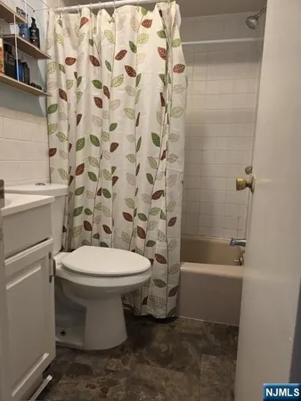 a white toilet sitting next to a bath tub