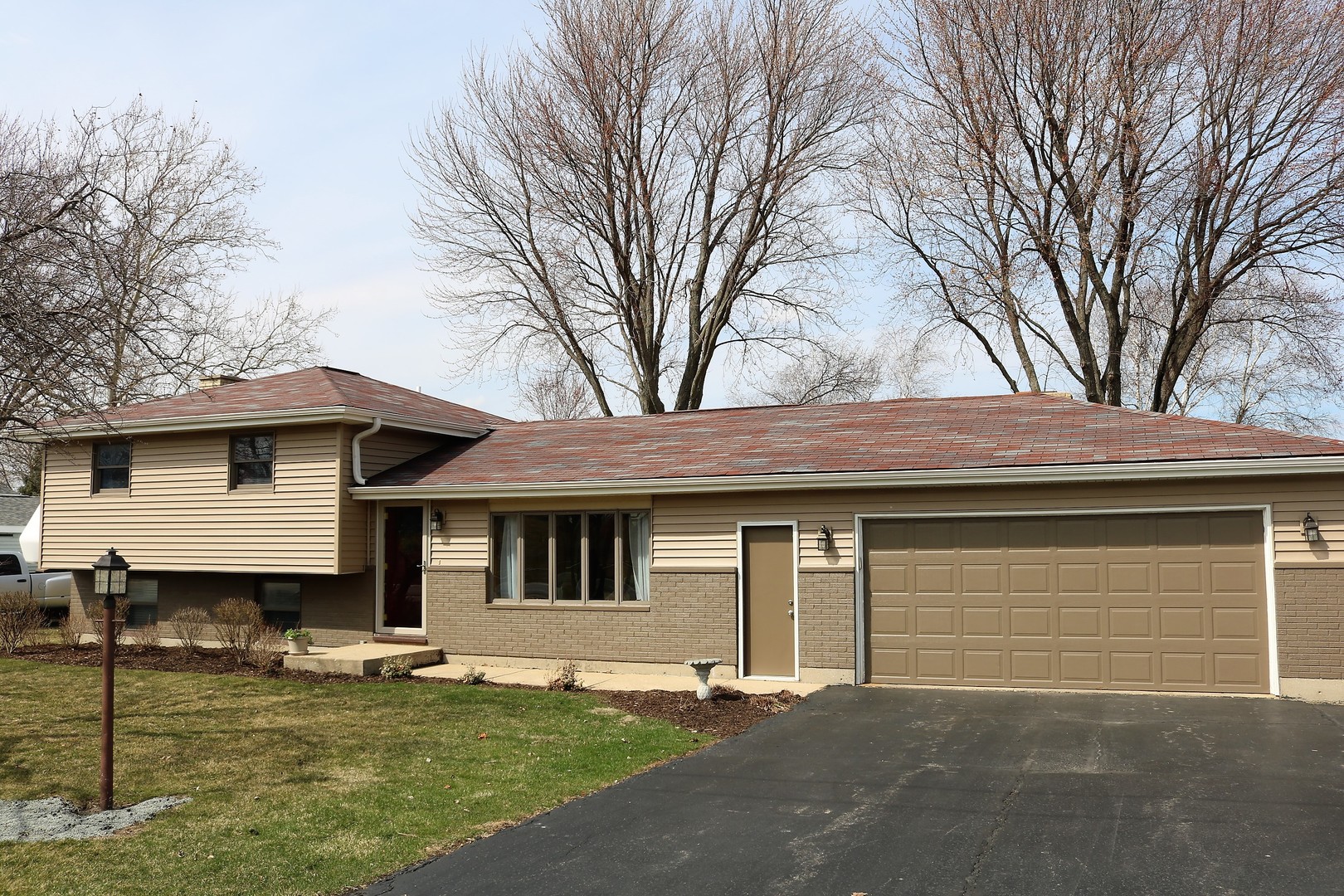 10167 Rich Road DeKalb, IL 60115 - Photo 1 of 31 a front view of a house with a garden and trees