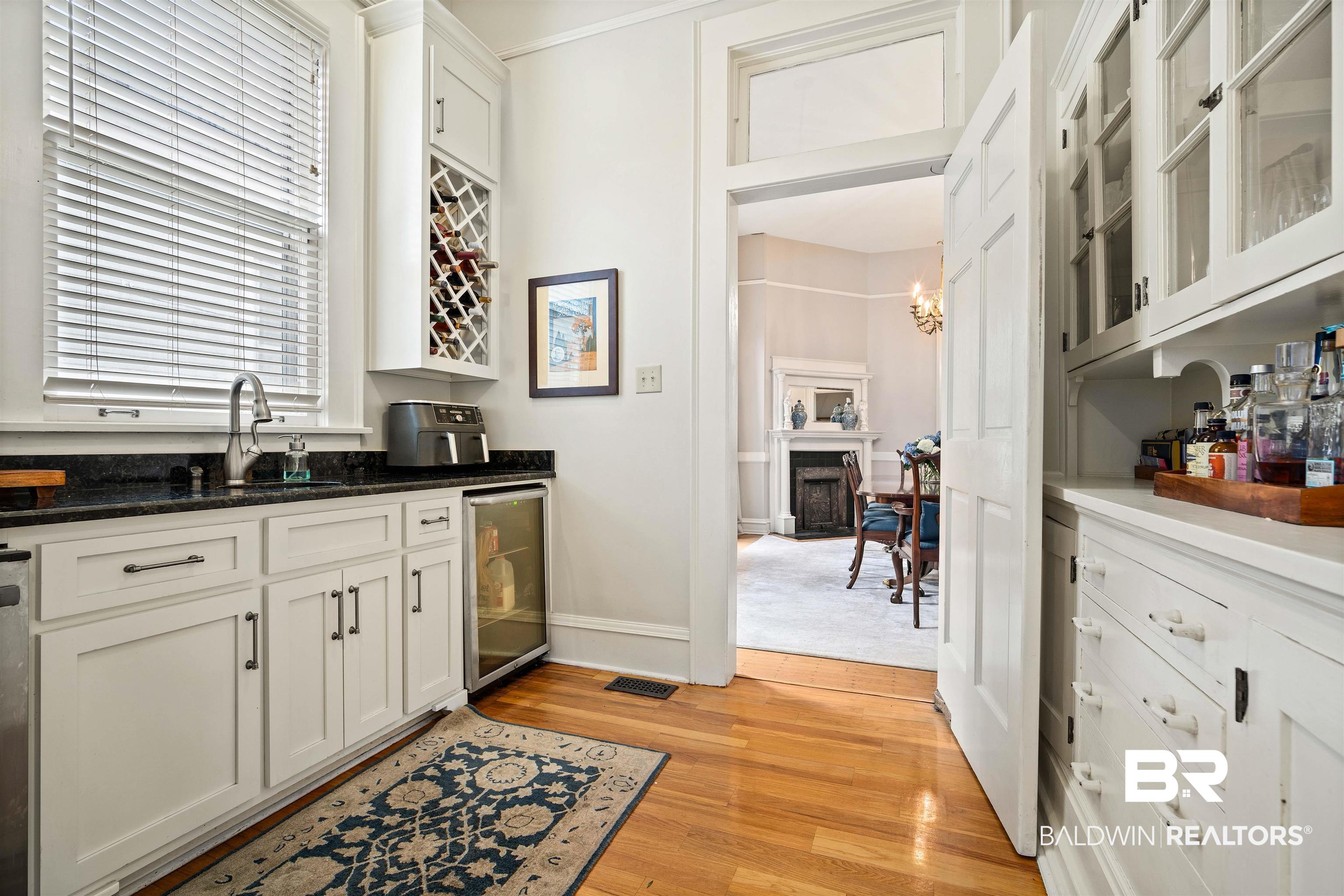 1314 Dauphin Street Mobile, AL 36604 - Photo 22 of 61 Bar with white cabinets, hardwood flooring, beverage cooler, and sink