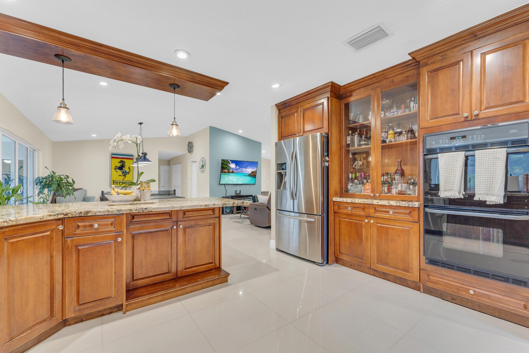 22057 Woodset Way Boca Raton, FL 33428 - Photo 10 of 51 a kitchen with stainless steel appliances kitchen island granite countertop a refrigerator and microwave