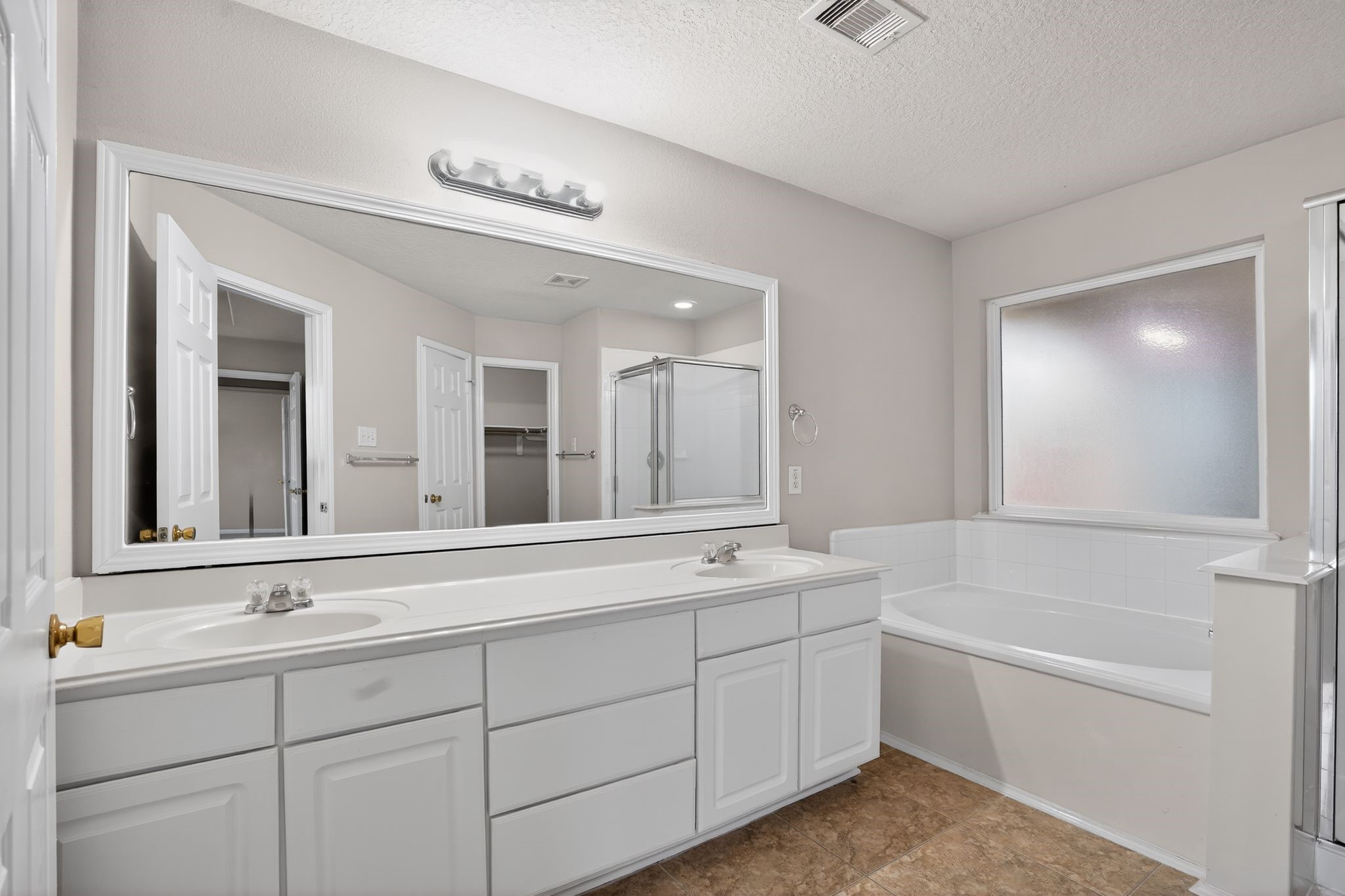 29414 Winton Wood Way Spring, TX 77386 - Photo 14 of 35 a bathroom with a sink a large mirror and a bathtub next to a window