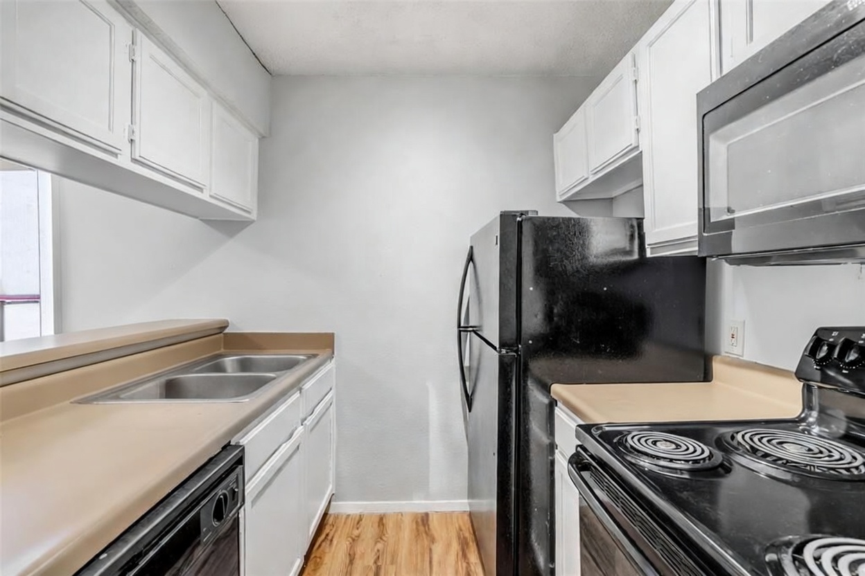 3115 Helms Street, Unit 210 Austin, TX 78705 - Photo 7 of 17 a kitchen with a sink stove and refrigerator