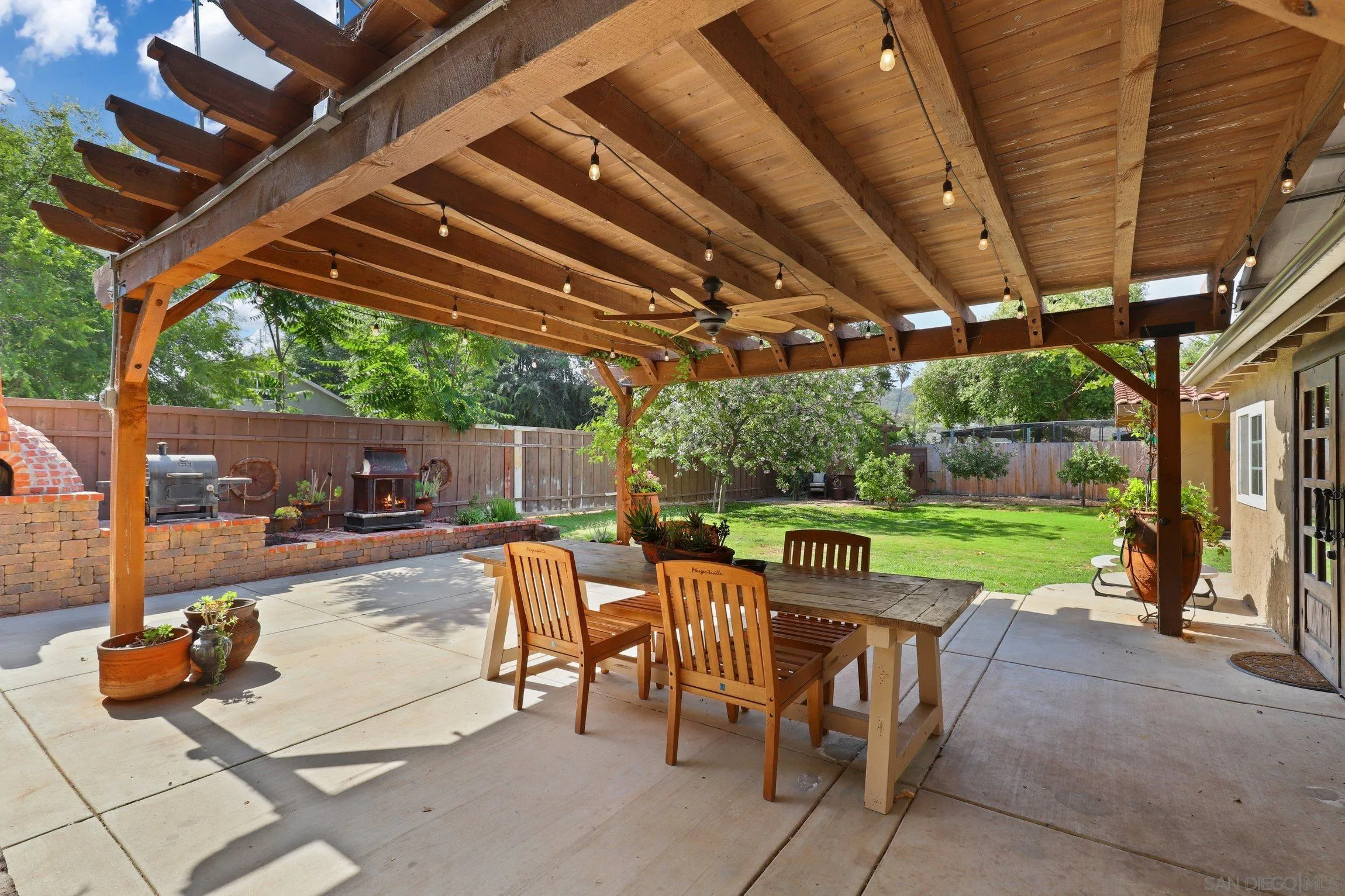 13107 Sudan Road Poway, CA 92064 - Photo 45 of 59 a view of a patio with table and chairs potted plants with wooden floor and roof
