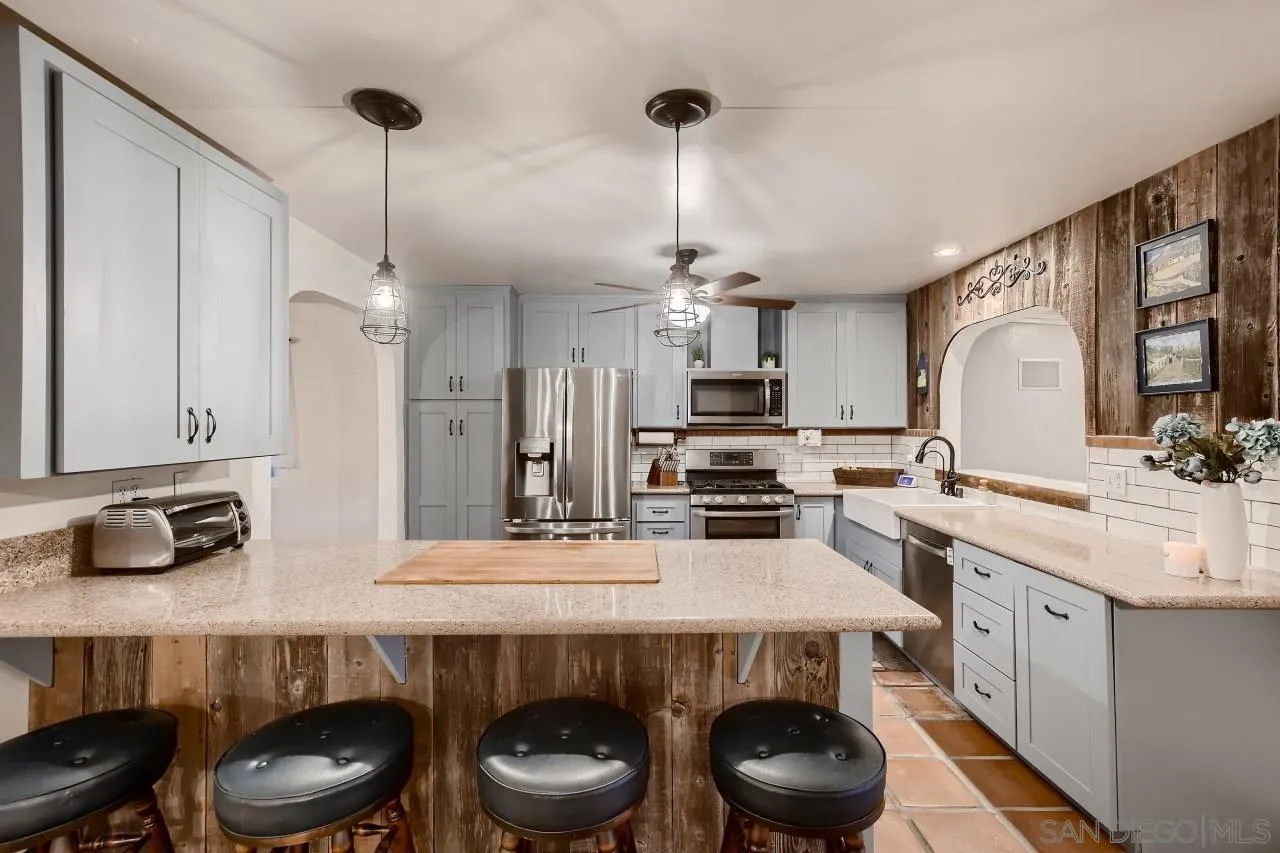 13107 Sudan Road Poway, CA 92064 - Photo 8 of 59 a kitchen with stainless steel appliances a stove and chairs