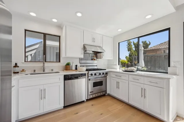 a kitchen with white cabinets and appliances