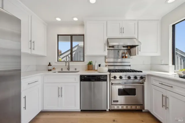 a kitchen with granite countertop a stove and a view of living room