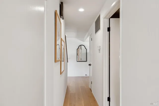 a view of hallway with stairs and wooden floor