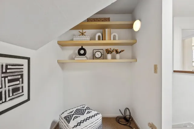 a view of a hallway with a couch and a livingroom with furniture