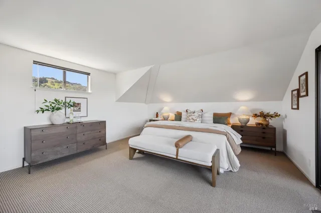 a spacious bedroom with a bed and a lamp