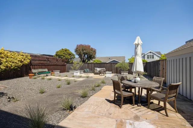 a view of a chair and tables in the back yard of the house
