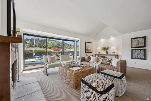 a living room with furniture kitchen view and a large window