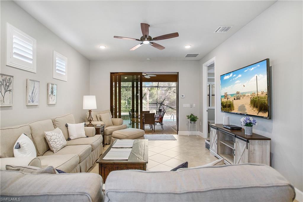 7674 Jacaranda Lane Naples, FL 34114 - Photo 2 of 45 a living room with furniture and a flat screen tv