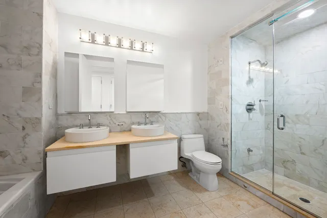 a bathroom with a double vanity sink mirror and toilet
