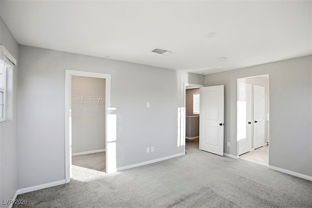 2865 Mincio Street Henderson, NV 89044 - Photo 11 of 33 Unfurnished bedroom with light colored carpet and a walk in closet