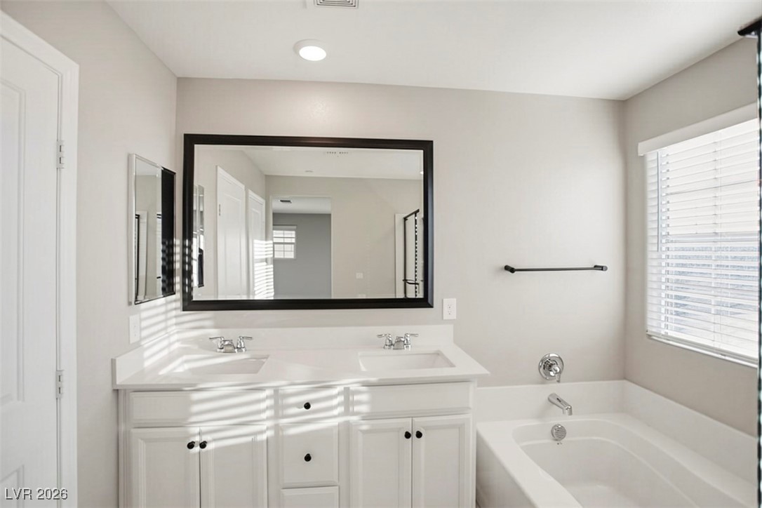 2865 Mincio Street Henderson, NV 89044 - Photo 15 of 33 Bathroom featuring double vanity and a garden tub