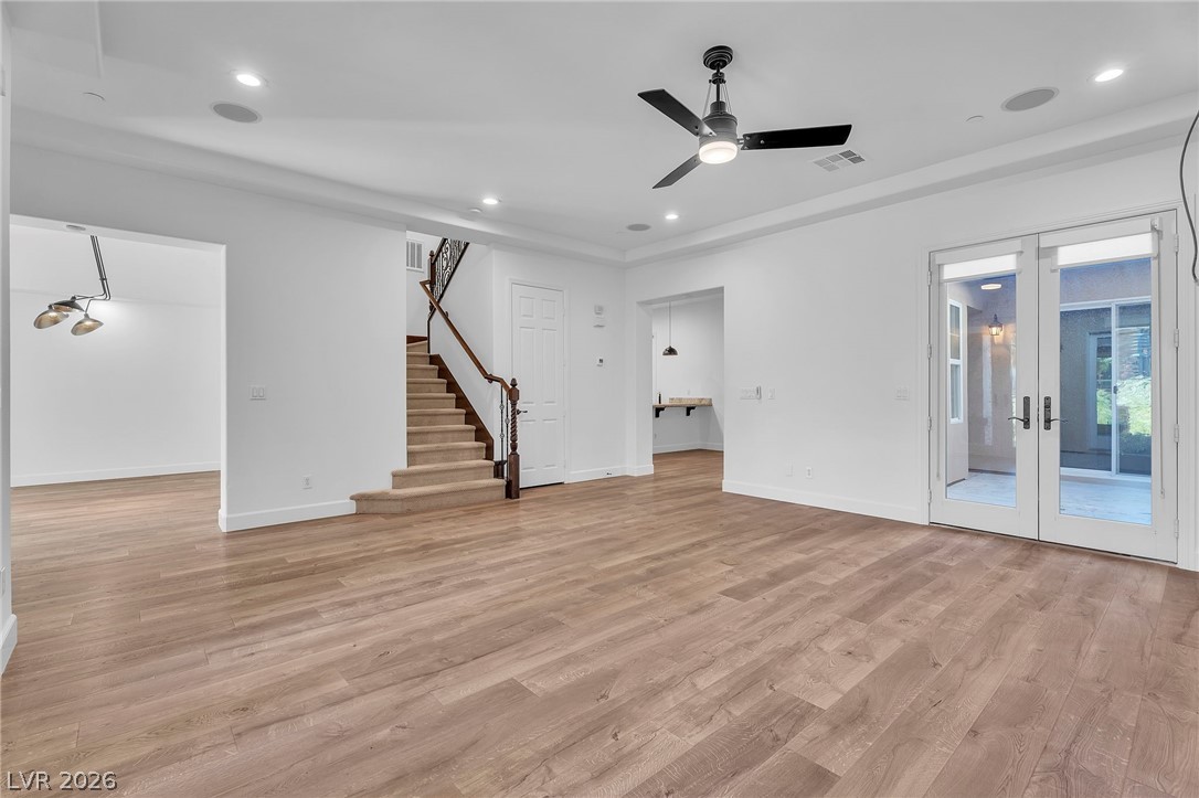 11280 Granite Ridge Drive, Unit 1037 Las Vegas, NV 89135 - Photo 15 of 51 Unfurnished living room featuring French doors, a ceiling fan, light wood-style floors, and recessed lighting