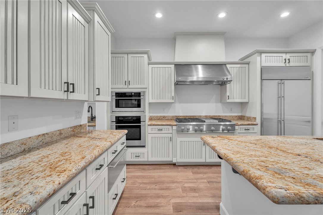 11280 Granite Ridge Drive, Unit 1037 Las Vegas, NV 89135 - Photo 20 of 51 Kitchen with stainless steel appliances, wood-style floors, a warming drawer, and recessed lighting, built in fridge, warming drawer, micro and oven (all Monogram)