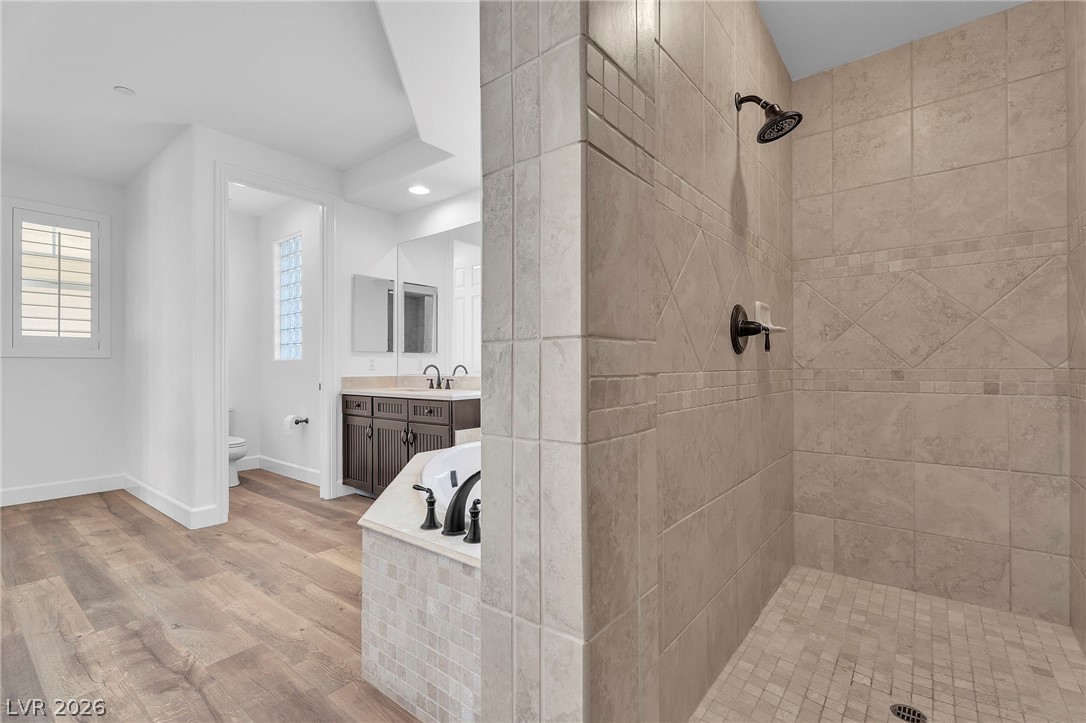 11280 Granite Ridge Drive, Unit 1037 Las Vegas, NV 89135 - Photo 28 of 51 Master bathroom with 2 separate vanities, a garden tubight wood-type flooring, tiled shower, recessed lighting