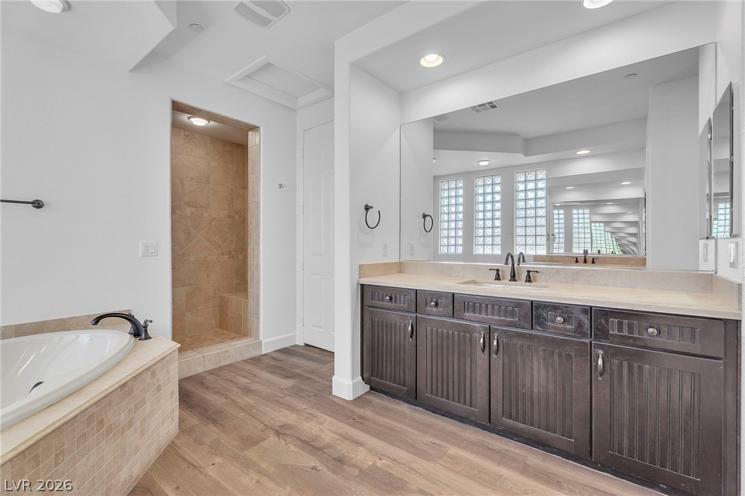 11280 Granite Ridge Drive, Unit 1037 Las Vegas, NV 89135 - Photo 31 of 51 Master Bathroom featuring separate vanities, light wood-style flooring, a walk-in shower, and recessed lighting. Rubbed Bronze faucets