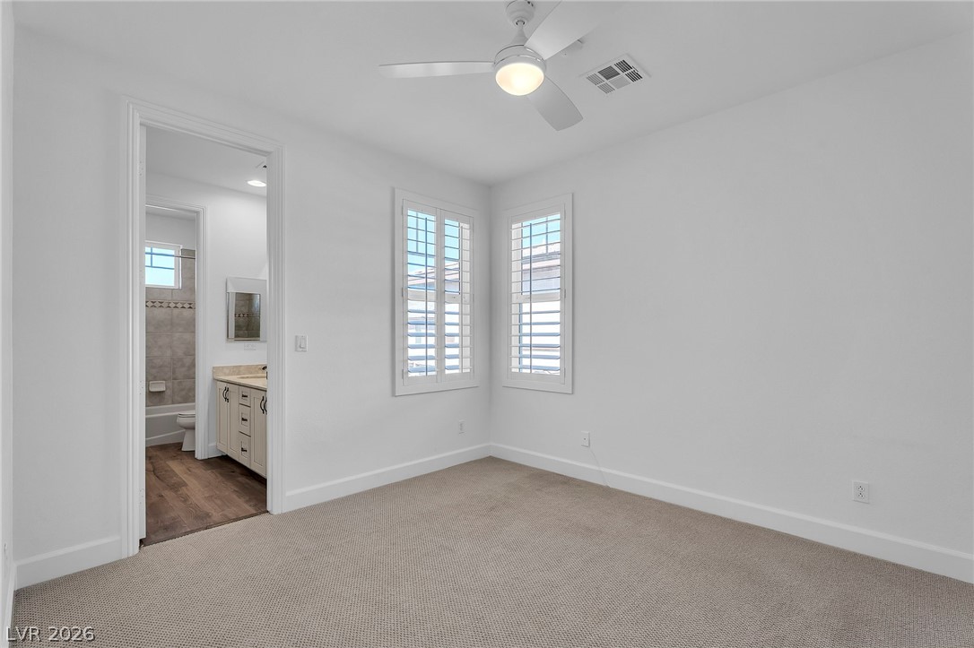 11280 Granite Ridge Drive, Unit 1037 Las Vegas, NV 89135 - Photo 33 of 51 Unfurnished bedroom featuring light carpet, ceiling fan, ensuite bath