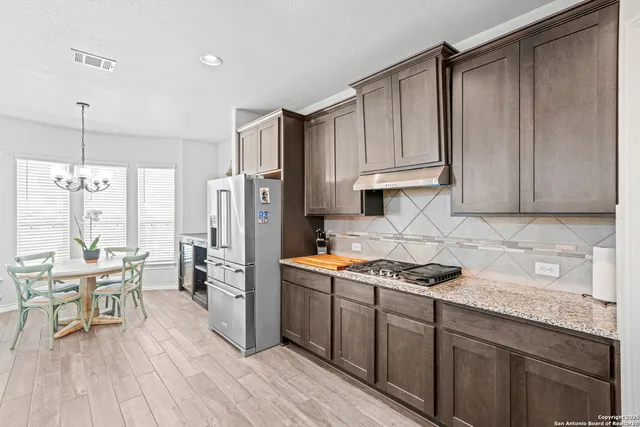 a kitchen with stainless steel appliances granite countertop a stove refrigerator and cabinets