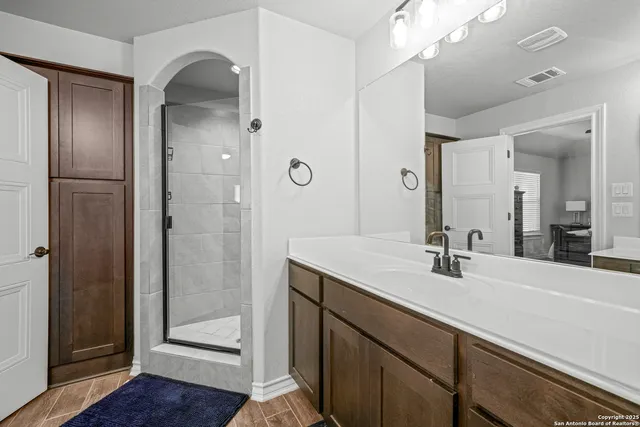 a bathroom with a double vanity sink mirror and shower