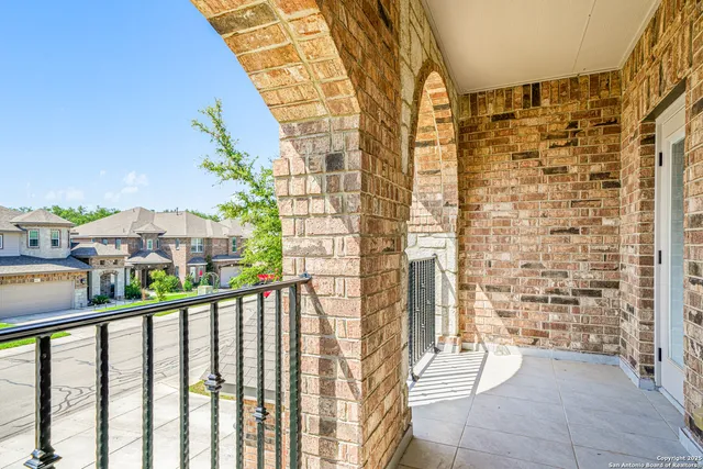 a view of a balcony with a couple of cars parked in front of a building