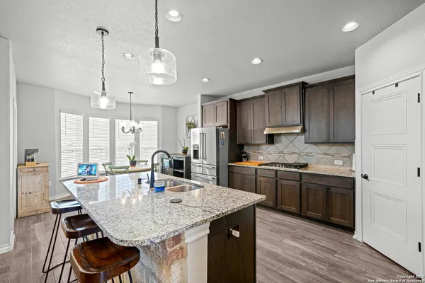 a kitchen with kitchen island granite countertop a sink and wooden cabinets