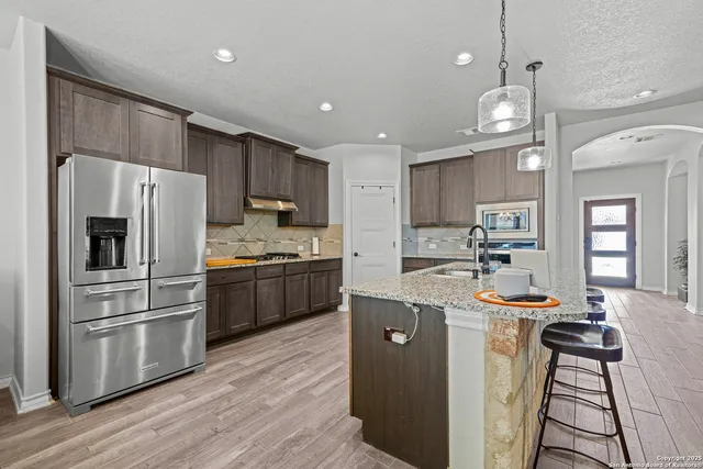 a kitchen with kitchen island a sink stainless steel appliances and window
