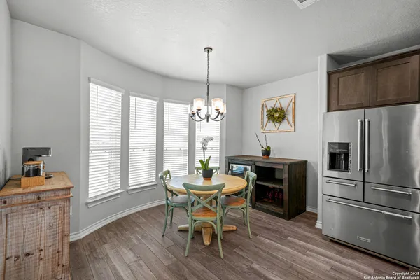 a dining room with furniture a chandelier and wooden floor