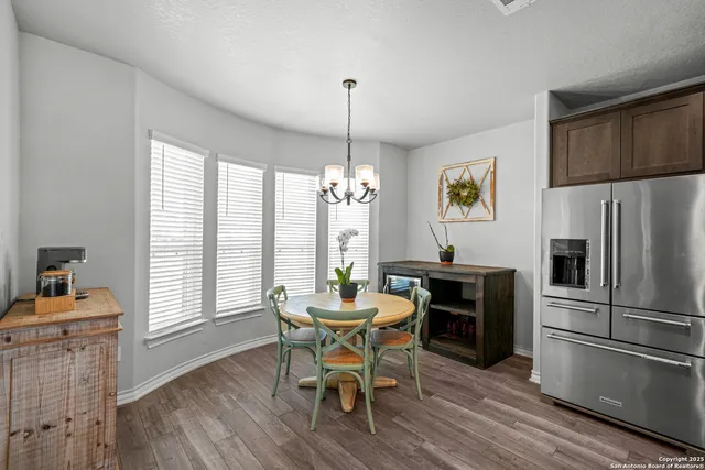 a dining room with furniture a chandelier and wooden floor