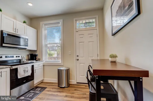 a kitchen with stainless steel appliances a stove a sink cabinets and a dining table