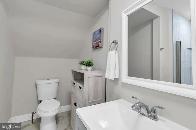 a bathroom with a toilet sink and mirror