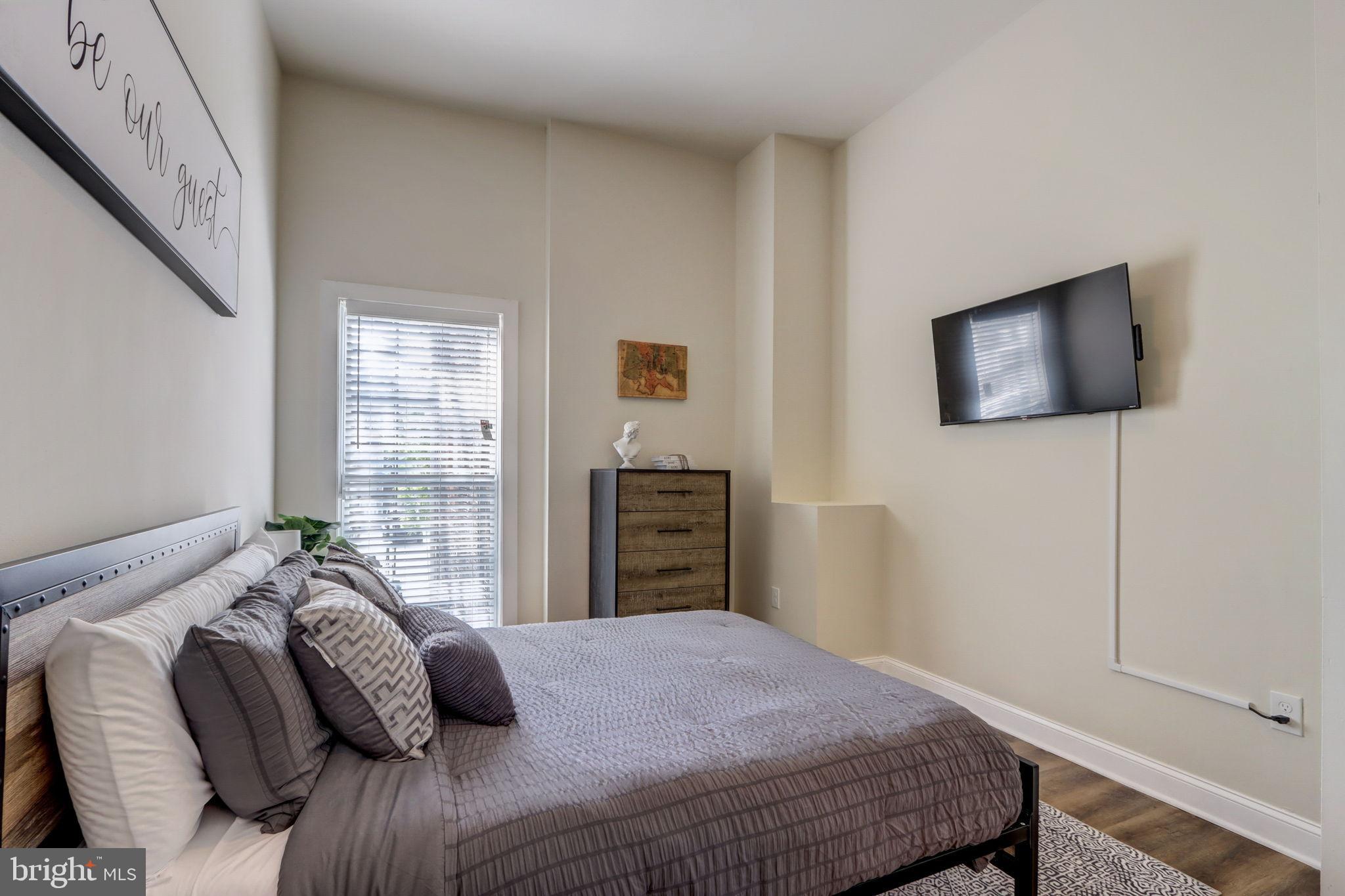 1628 North Calvert Street Baltimore, MD 21202 - Photo 19 of 50 a bedroom with a bed and a television