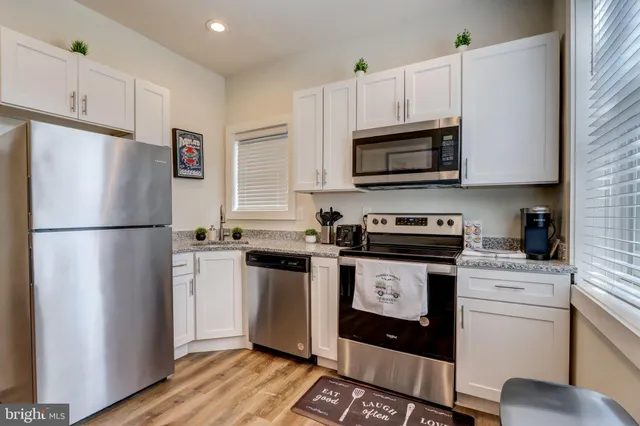 a kitchen with stainless steel appliances granite countertop a refrigerator stove a sink and a microwave