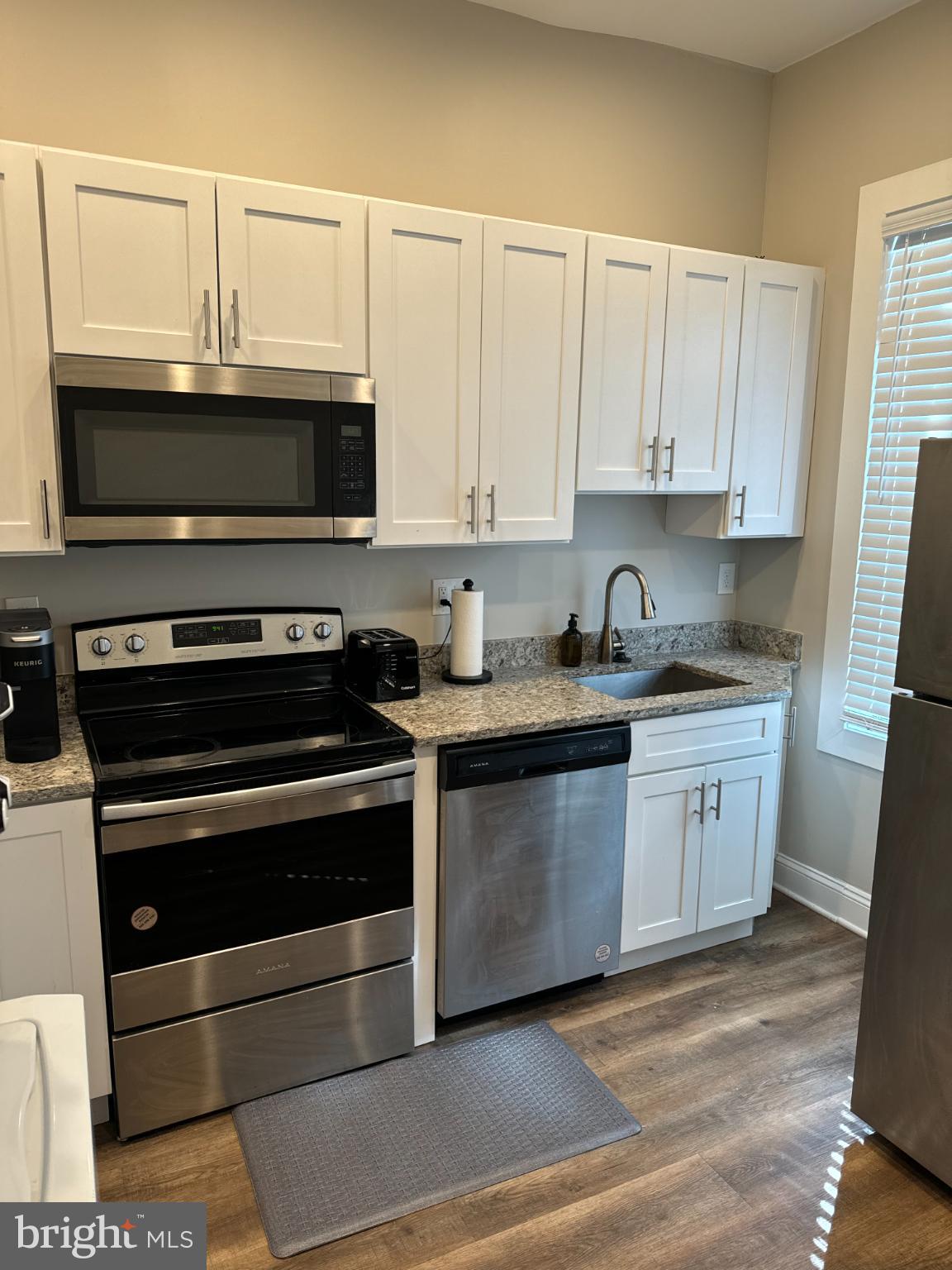 1628 North Calvert Street Baltimore, MD 21202 - Photo 32 of 50 a kitchen with granite countertop a stove microwave and sink