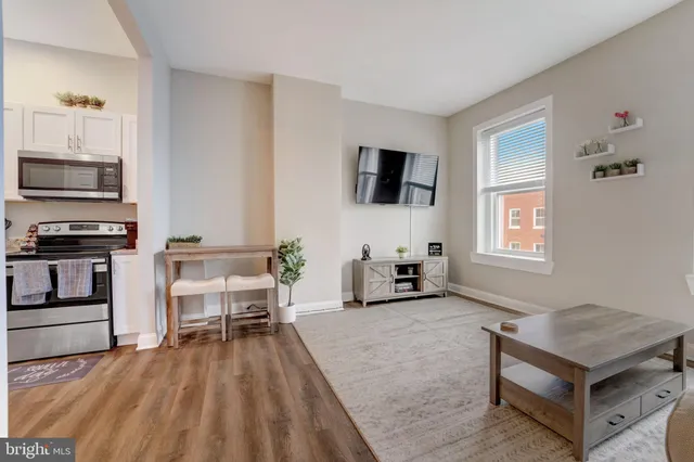 a living room with furniture and a refrigerator