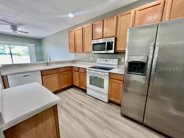 15655 Stable Run Drive Spring Hill, FL 34610 - Photo 10 of 48 a kitchen with stainless steel appliances granite countertop white cabinets a sink a stove a refrigerator with grey cabinets and wooden floor