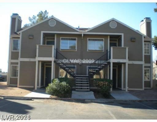 View of front of house featuring stairs and a chim