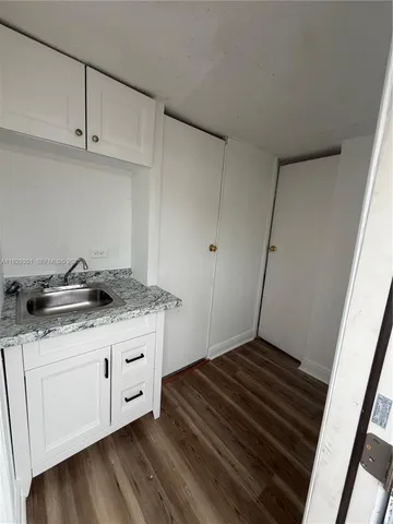 a kitchen with granite countertop a sink and cabinets