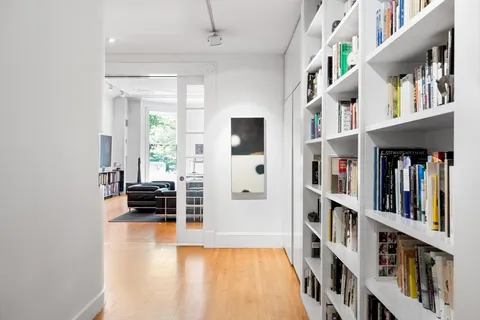 a living room with lots of furniture and baby book shelf