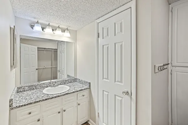 a bathroom with a granite countertop sink and a mirror