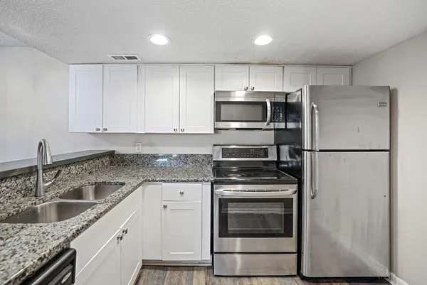 a kitchen with a sink stove and refrigerator