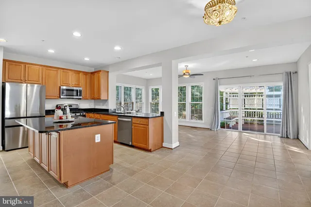 a kitchen with stainless steel appliances granite countertop a stove a refrigerator a sink a microwave and island